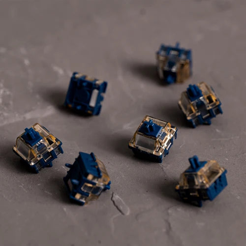 7 navy magnetic keyboard switches laid out on a concrete floor