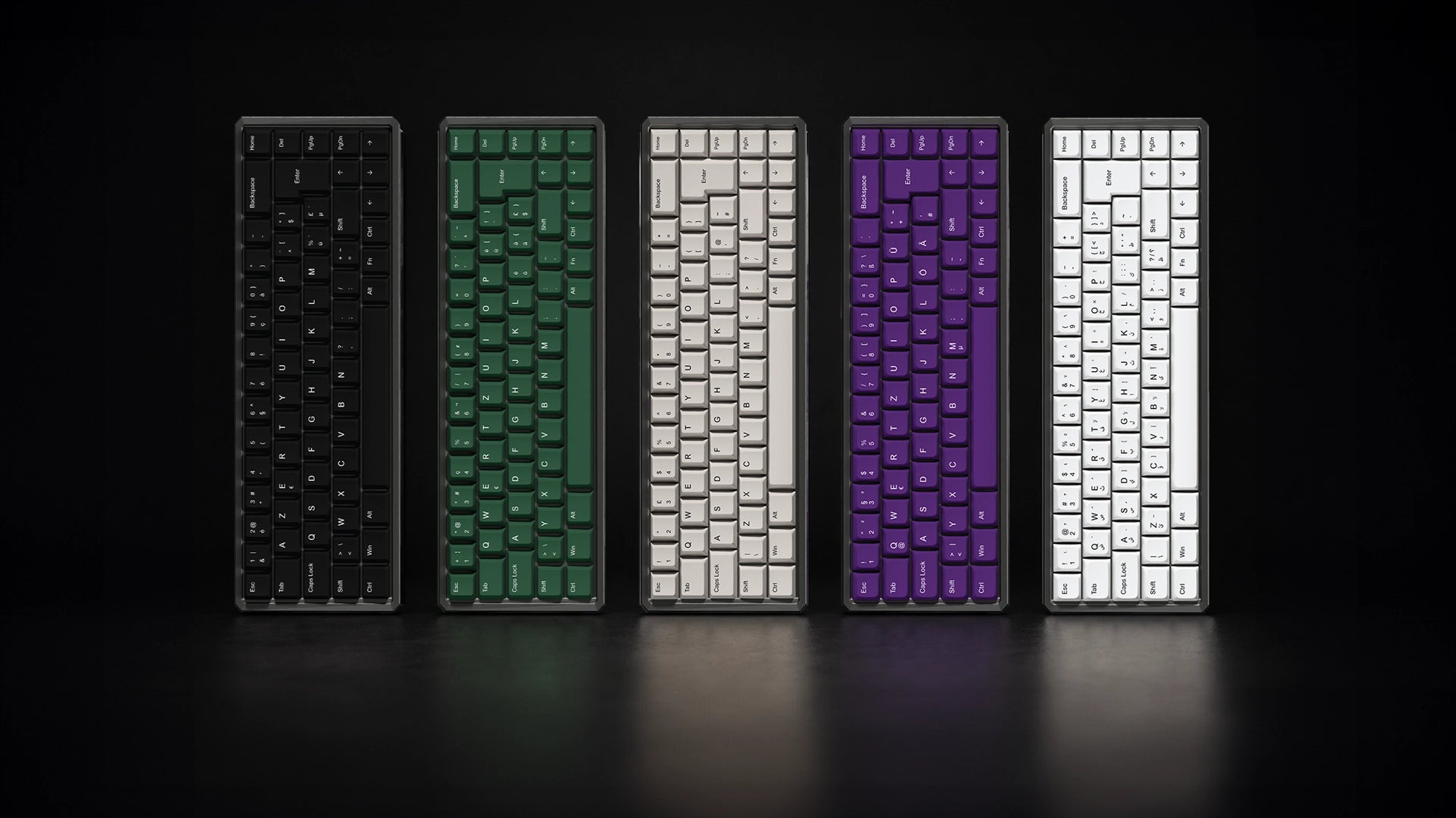 Five compact mechanical keyboards shown upright in a row on a dark surface against a black background, each in a different keycap color: black, green, white, purple, and white.